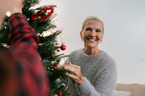 Daughter and mother caucasian decorate Christmas tree to prepare for familys Christmas Day. - Photo, Image