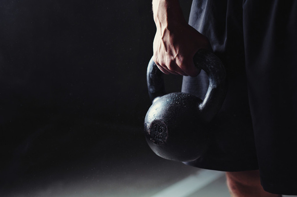 Hand holding a kettlebell - Foto, afbeelding