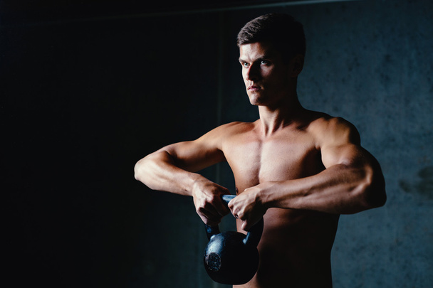 Muscular athlete with a kettlebell - Photo, Image