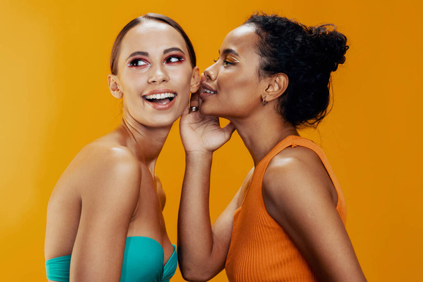 2 人の女性の少女はレースの美しさの多彩な幸せな混合された目の構造のスキン アフリカのアメリカのモデル黄色はスタジオの慎重な肖像のボディケアを一緒に美しく健康な魅力を輝かせます - 写真・画像
