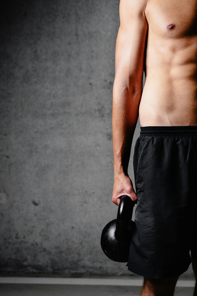 Athletic torso and hand holding kettlebell - Photo, Image