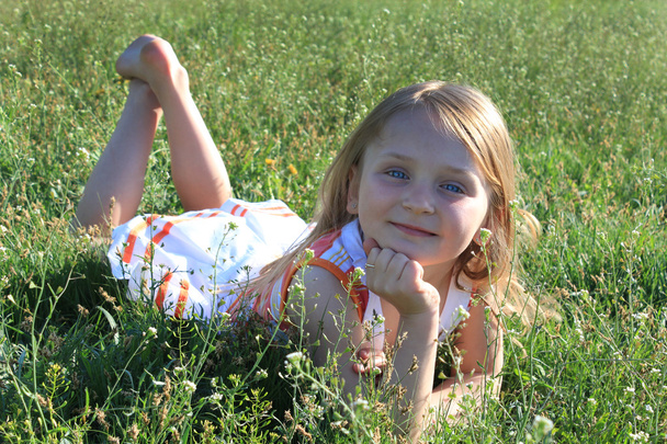 Retrato de una niña tendida en la hierba
 - Foto, imagen