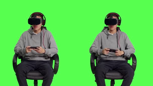 No estúdio, o homem asiático gosta de jogos de telefone com óculos de realidade virtual, competindo em rpg on-line usando o software móvel vr no fone de ouvido. Jovem jogador adulto desfrutando de bons momentos com seus amigos. - Filmagem, Vídeo