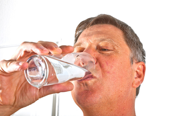 Portret van aantrekkelijke man drinkwater - Foto, afbeelding