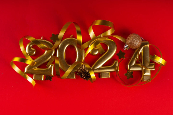 Feliz ano novo 2024 fundo do cartão de saudação com números de ouro, garrafa de champanhe, serpentina, Natal e Ano Novo decorações no espaço de cópia de fundo vermelho - Foto, Imagem