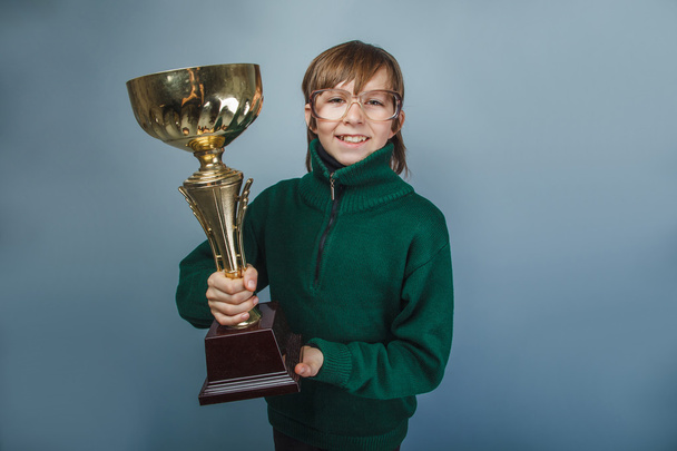 European-looking boy of ten years in glasses  holding a cup - Φωτογραφία, εικόνα