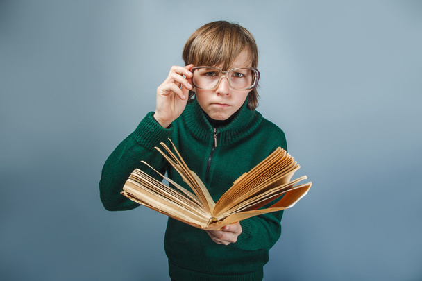 European-looking boy of ten years in glasses  reading  a book on - Фото, изображение
