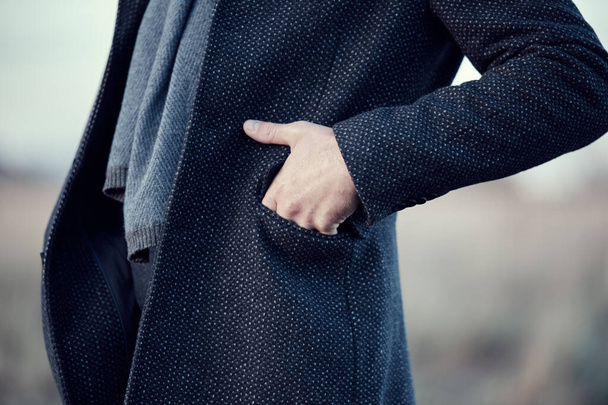 Tengerészkék kabátos férfi, kék gyapjúsállal, kéz a kézben. Meleg klasszikus őszi téli férfi ruházat - Fotó, kép