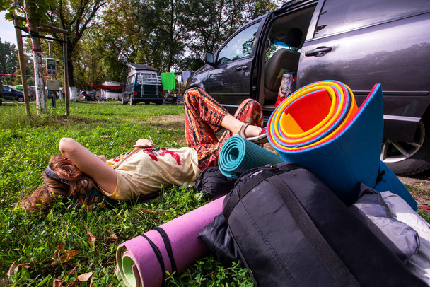 šťastná dospívající dívka leží na trávě a poslouchá hudbu. Teen tábor a psychologické zdraví dospívajících - Fotografie, Obrázek