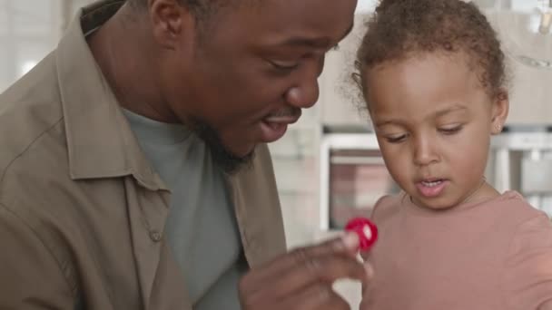 feliz afro-americano padre besos adorable niño hija y sonriendo mientras pasando familia tome en casa - Imágenes, Vídeo