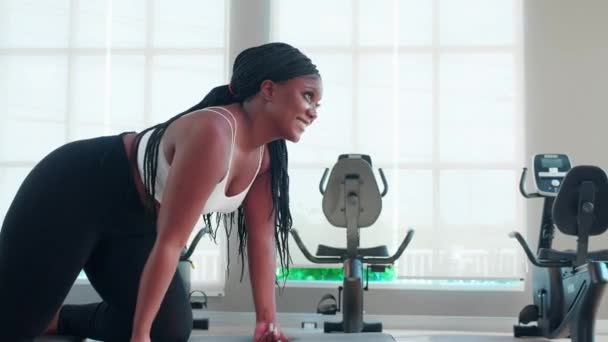 若い黒人女性のトレーニング エクササイズやトレーニング フィットネスジムで強いボディービルダーのためのダンベルを持ち上げる, 筋肉とモチベーションの強さのために重量挙げを実践する女性, スポーツコンセプト. - 映像、動画