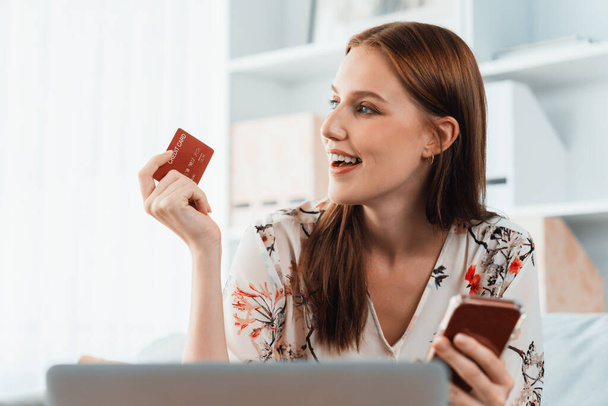 Νεαρή ευτυχισμένη γυναίκα αγοράζουν προϊόν με online αγορές στο σπίτι, ενώ η παραγγελία στοιχείων από το διαδίκτυο με πιστωτική κάρτα σε απευθείας σύνδεση σύστημα πληρωμών προστατεύεται από τη μέγιστη ασφάλεια στον κυβερνοχώρο από το ηλεκτρονικό κατάστημα πλατφόρμα - Φωτογραφία, εικόνα
