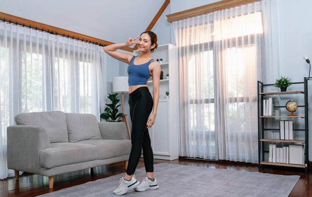 Full body asian woman in sportswear portrait, smiling and posing cheerful gesture. Home workout training with attractive girl engage in her pursuit of healthy lifestyle. Vigorous - Photo, Image