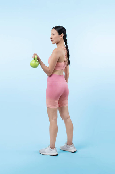Dinç, enerjik bir kadın izole edilmiş arka planda ağırlık kaldırma egzersizi yapıyor. Genç atletik Asyalı kadın dayanıklılığı ve dayanıklılık eğitimi rutin vücut egzersizi.. - Fotoğraf, Görsel