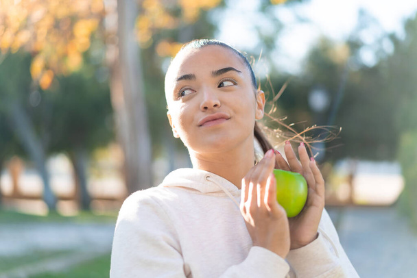 Giovane bella donna sportiva in possesso di una mela - Foto, immagini