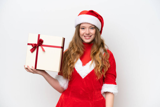 Молодая белая женщина в рождественском платье с подарком на белом фоне, улыбаясь много - Фото, изображение