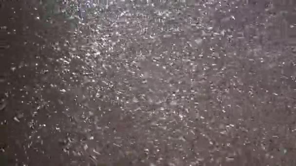The first snow falls from the sky at night in the light of street lamps. - Footage, Video