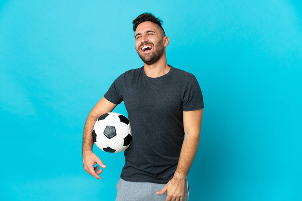 Football joueur isolé sur fond bleu riant - Photo, image