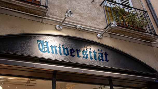 Un'immagine con un cartello in tedesco che indica la direzione dell'università. - Foto, immagini