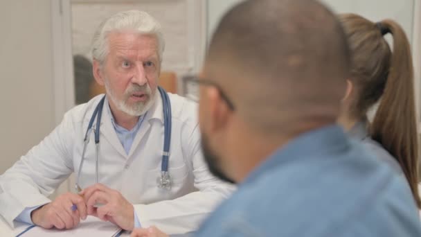 Ανώτερος γιατρός Συζητώντας σχέδιο θεραπείας με τους ασθενείς - Πλάνα, βίντεο