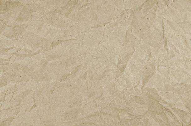  Tactile texture of crumpled beige paper. Wrinkled wrapping paper background. Packaging paper. The light beige paper tone is muted but rich, with warm hues. - Photo, Image