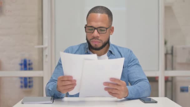 Смешанный расовый человек работает над документами - Кадры, видео