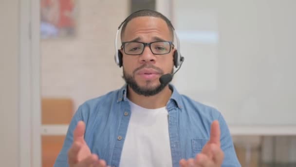 Hombre africano que habla con auriculares en el centro de llamadas - Imágenes, Vídeo