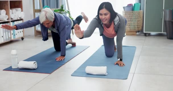 Nő, beteg és idősek gondozása jóga órán fitnesz, ápoló vagy nyújtózkodó testre az idősek otthonában. Női ápoló, személyi edző vagy gondozó segít az idős személynek a matracon végzett egészséges zen testmozgásban. - Felvétel, videó