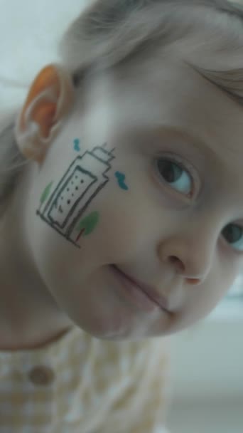 Petite fille mignonne sérieuse avec bâtiment moderne dessinant sur son visage. Concept d'architecture - Séquence, vidéo