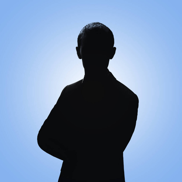Silhouette eines Mannes. Mann posiert im Anzug auf blauem Hintergrund - Foto, Bild