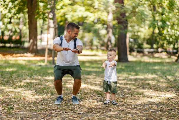 Ojciec uczący się i syn ćwiczących i sportowych w naturze. - Zdjęcie, obraz