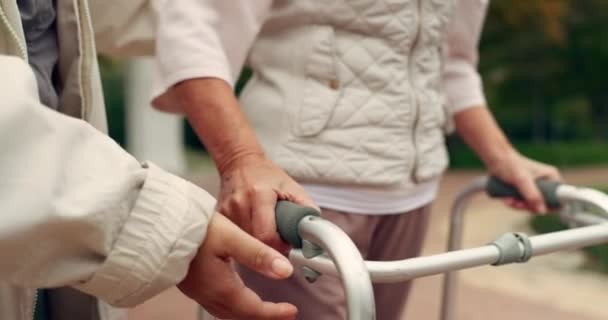 Kädet, tuki ja vanhempi henkilö, jolla on kävelijä vammojen kuntoutukseen, kävelyyn ja fysioterapiaan. Terveydenhuolto, vammainen potilas ja hoitovälineet eläkkeellä olevaa hoitajaa varten. - Materiaali, video