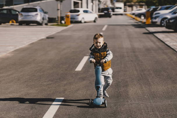 Şirin çocuk sokakta scooter sürüyor.. - Fotoğraf, Görsel