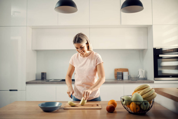 Sağlıklı bir kadın atıştırmak için elma kesiyor.. - Fotoğraf, Görsel