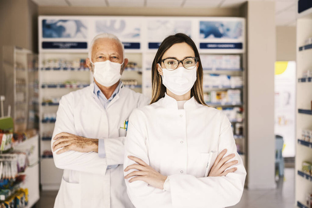 Jeunes et vieux pharmaciens avec masque posé en pharmacie. - Photo, image