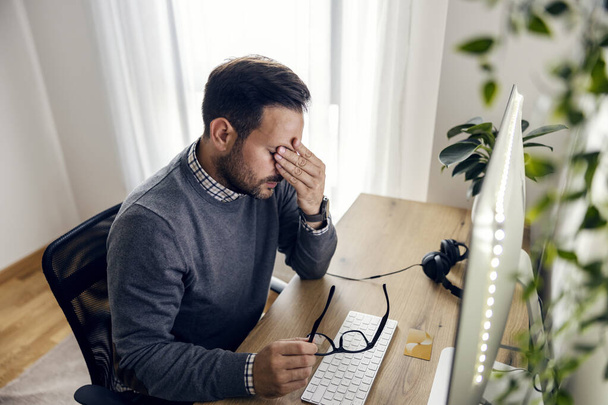 Wyczerpany start-up biznesmen z bólem głowy podczas siedzenia w biurze. - Zdjęcie, obraz