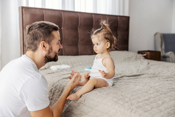 Счастливый отец разговаривает со своей дочерью и учит ее говорить. - Фото, изображение