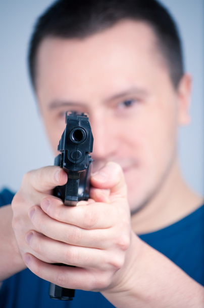 Young man holding a pistol - Valokuva, kuva