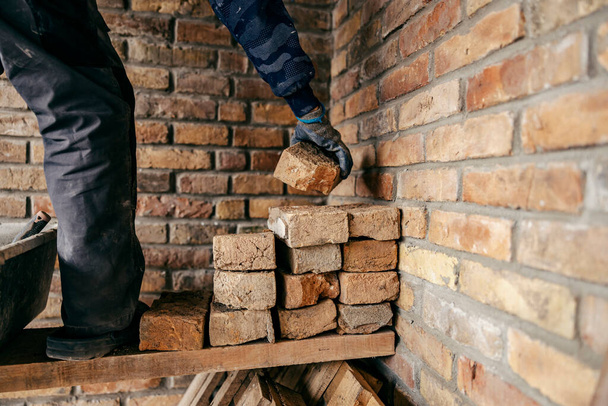 Imagen recortada de un constructor de viviendas de pie sobre un andamio y haciendo una casa. - Foto, Imagen