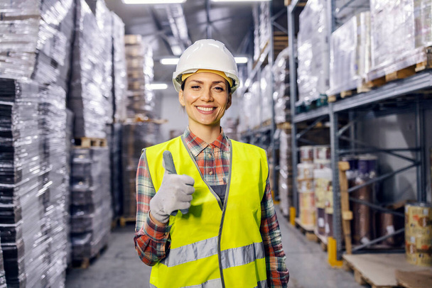 Portrait of a storage worker giving thumbs up while smiling at the camera. - Photo, Image