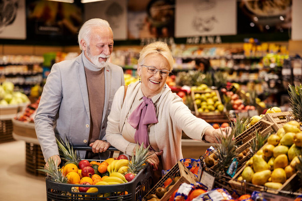 Ένα ηλικιωμένο ζευγάρι αγοράζει φρούτα από το σούπερ μάρκετ.. - Φωτογραφία, εικόνα