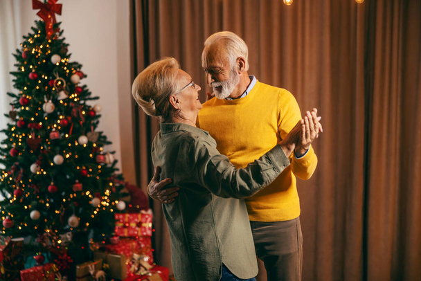 Αγαπημένοι παππούδες χορεύουν τα Χριστούγεννα και το νέο έτος. - Φωτογραφία, εικόνα