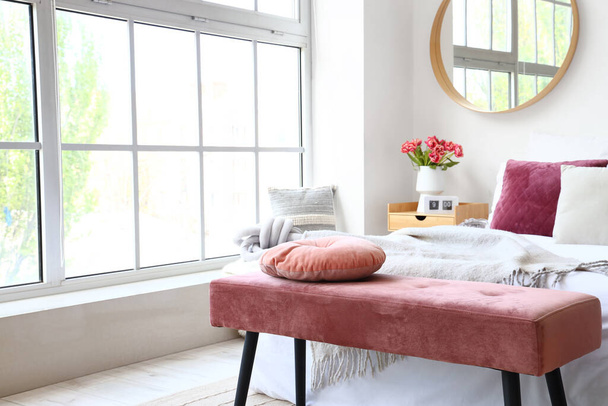 Інтер'єр світлої спальні з рожевою лавкою і дзеркалом - Фото, зображення