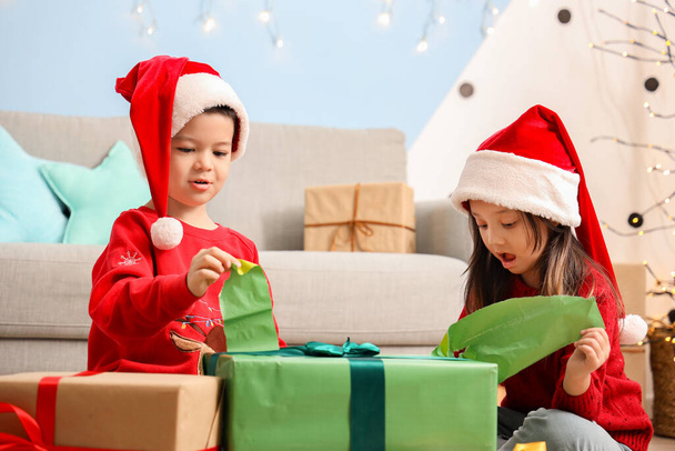 Adorables niños pequeños abriendo regalo de Navidad en casa - Foto, imagen