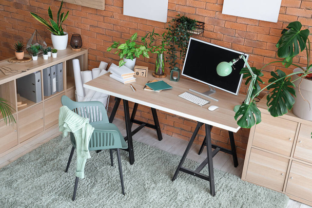 Interiér stylové kanceláře s moderním pracovištěm, regálovou jednotkou a pokojovými rostlinami - Fotografie, Obrázek