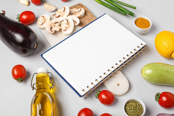 Composition with blank recipe book, vegetables and spices on grey background - Photo, Image