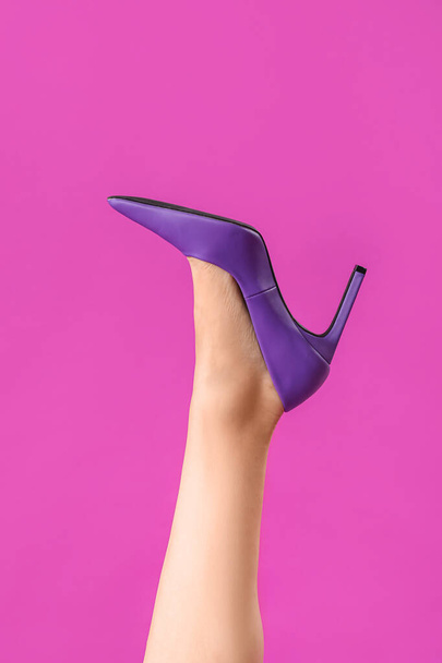 Leg of young woman in stylish purple high heel on color background - Photo, Image
