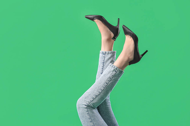 Nohy mladé ženy ve stylové černé vysoké podpatky na zeleném pozadí - Fotografie, Obrázek