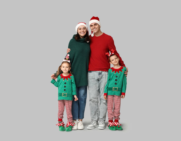 Happy family in Christmas clothes on grey background - Photo, Image