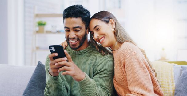 Couple, living room sofa and texting with phone, smile and click for contact, meme and notification in home. Man, woman and happy with smartphone, reading and app for social network, video and relax. - Photo, Image